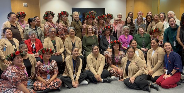 A group of women stand together and smile for a photo