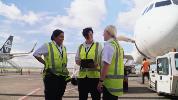 Women in High Vis vests talking on a runway