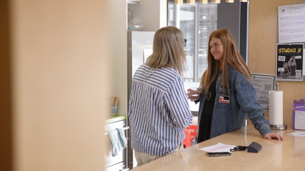 Two women talking in an office Kitchen
