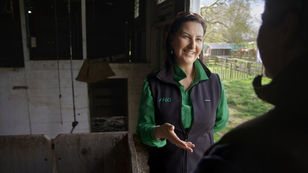 Image of Andrea from FMG talking to a client in a woolshed