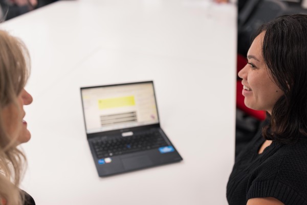 Two women colleagues in discussion with laptop